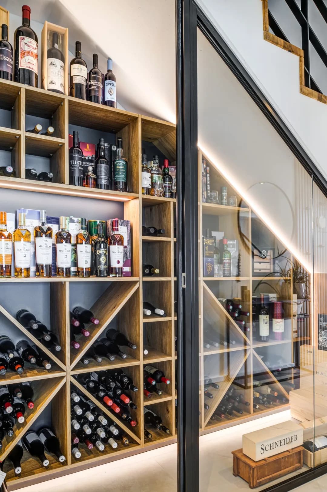 Maßgefertigtes Weinregal mit integrierter Beleuchtung und dunklen Flaschenfächern